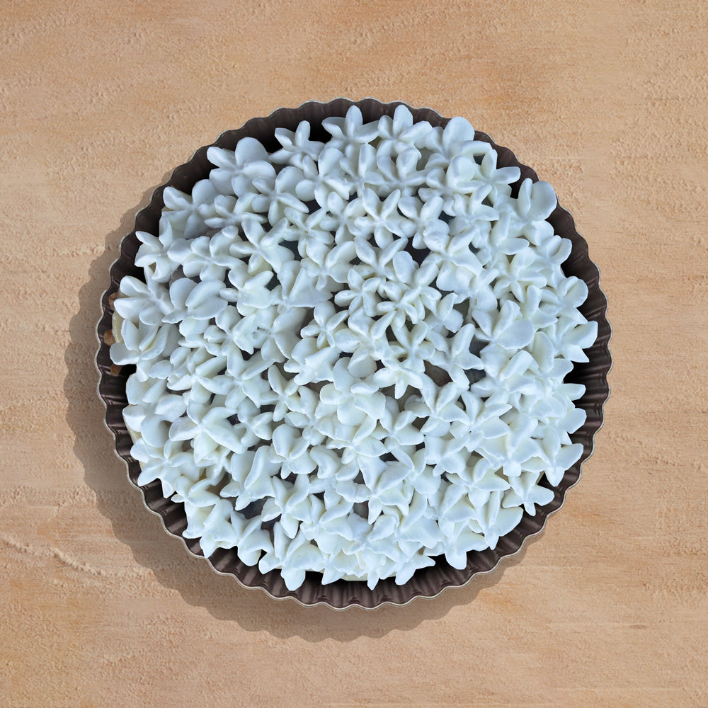 Decorative banana cream pie white coral-like material on a wooden surface